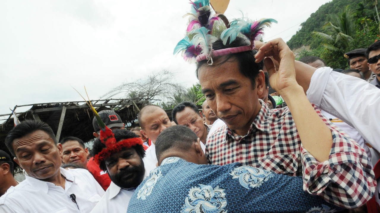 PROMISES. Joko Widodo (R) wears a Papuan traditional head wear during his presidential campaign rally in Jayapura, Papua, in June 2014. Photo by EPA 