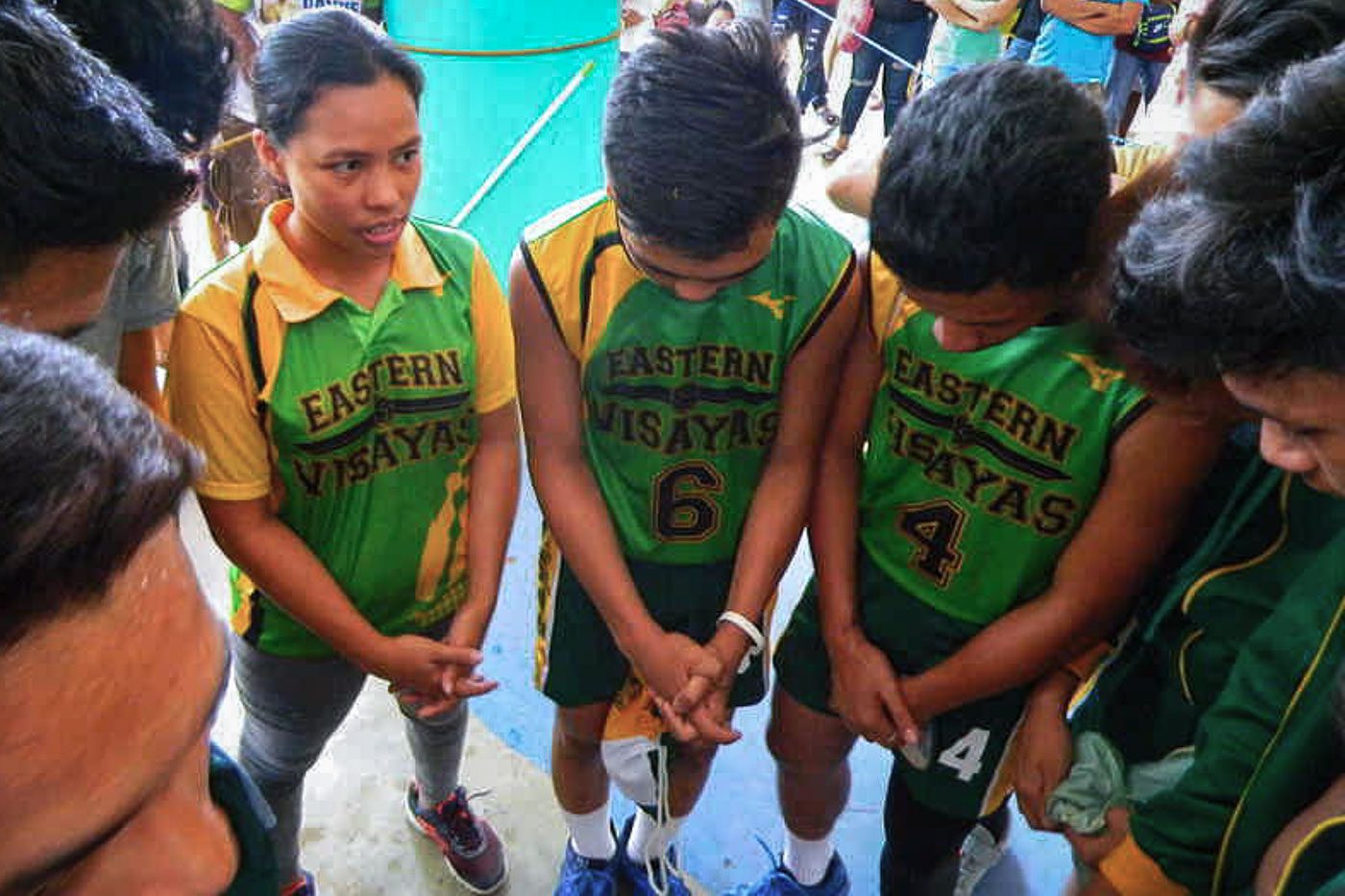 BEYOND SPORTS COACHING. Eastern Visayas volleyball boys secondary coach Teresa Salas leads her team as they pray after winning the preliminary game against Bicol Region at Simbalom Municipal Gym. Photo by Jake De La Justa/ Rappler 