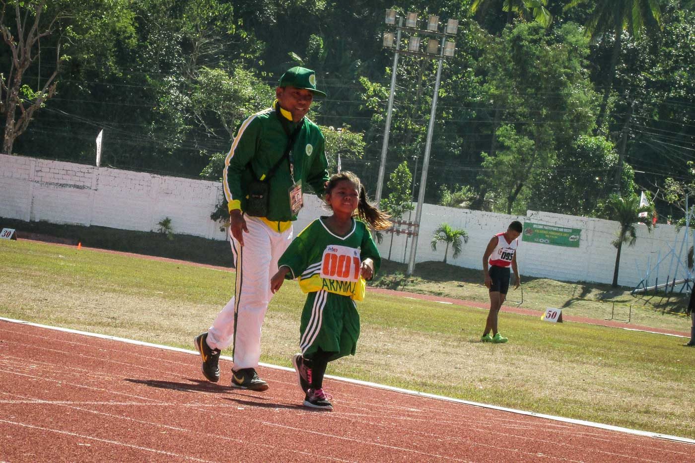 TOGETHER TOWARDS THE END. ARMM Coach assists his trainee finish the race even when all the other competitors have already reached the end. Photo by Cecil Solidon/ Rappler 