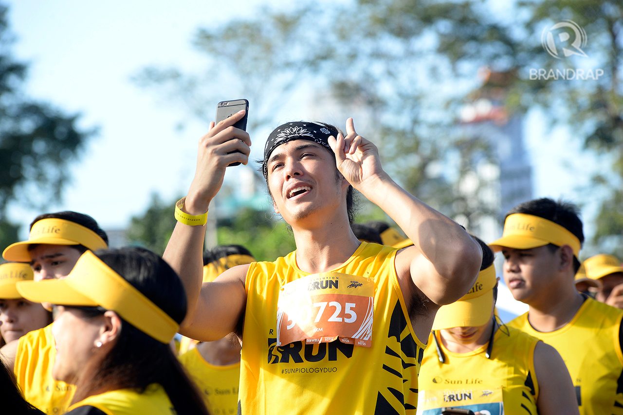 FUN TIME WITH FANS. Ex-Pinoy Big Brother Housemate Tommy Esguerra takes the time to vlog the run alongside fans. Photo by Maria Tan/Rappler 