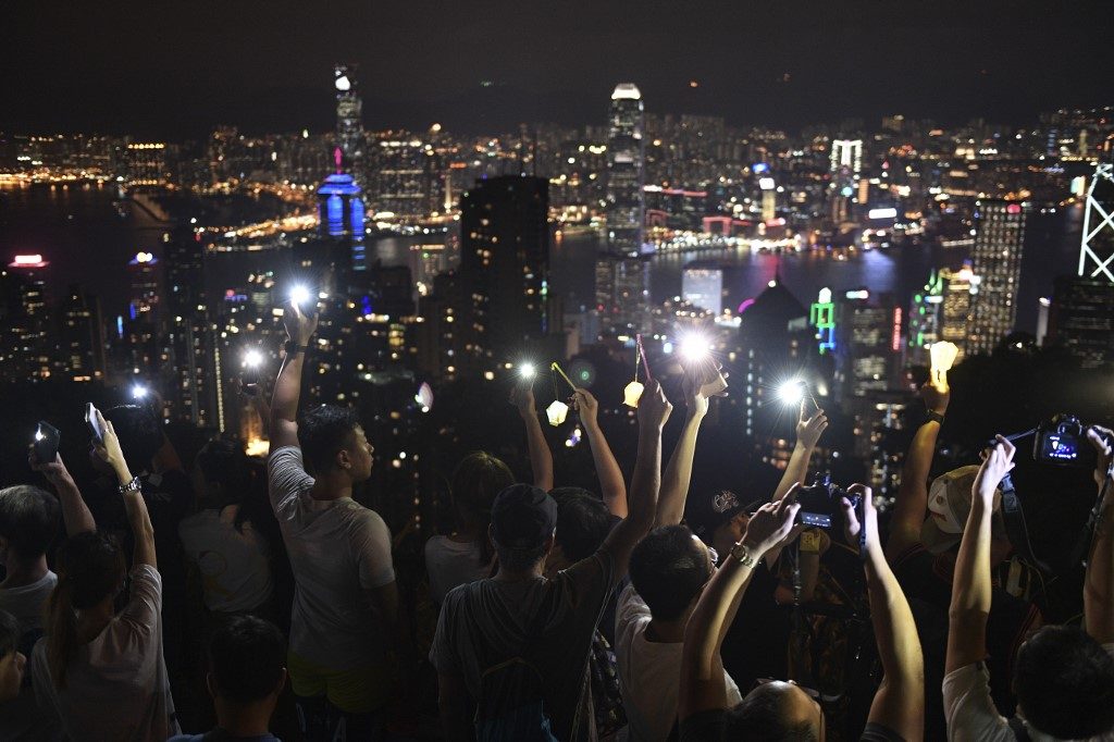 Hong Kong hills shine with protest lights in festival-themed rally