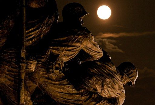 LONG EXPOSURE NOT A REQUIREMENT.  A supermoon rises above the U.S. Marine Corps War Memorial on August 10, 2014 in Arlington, Virginia. Look for a lighted statue or any structure for an interesting foreground. Photo by Win McNamee/Getty Images/AFP  