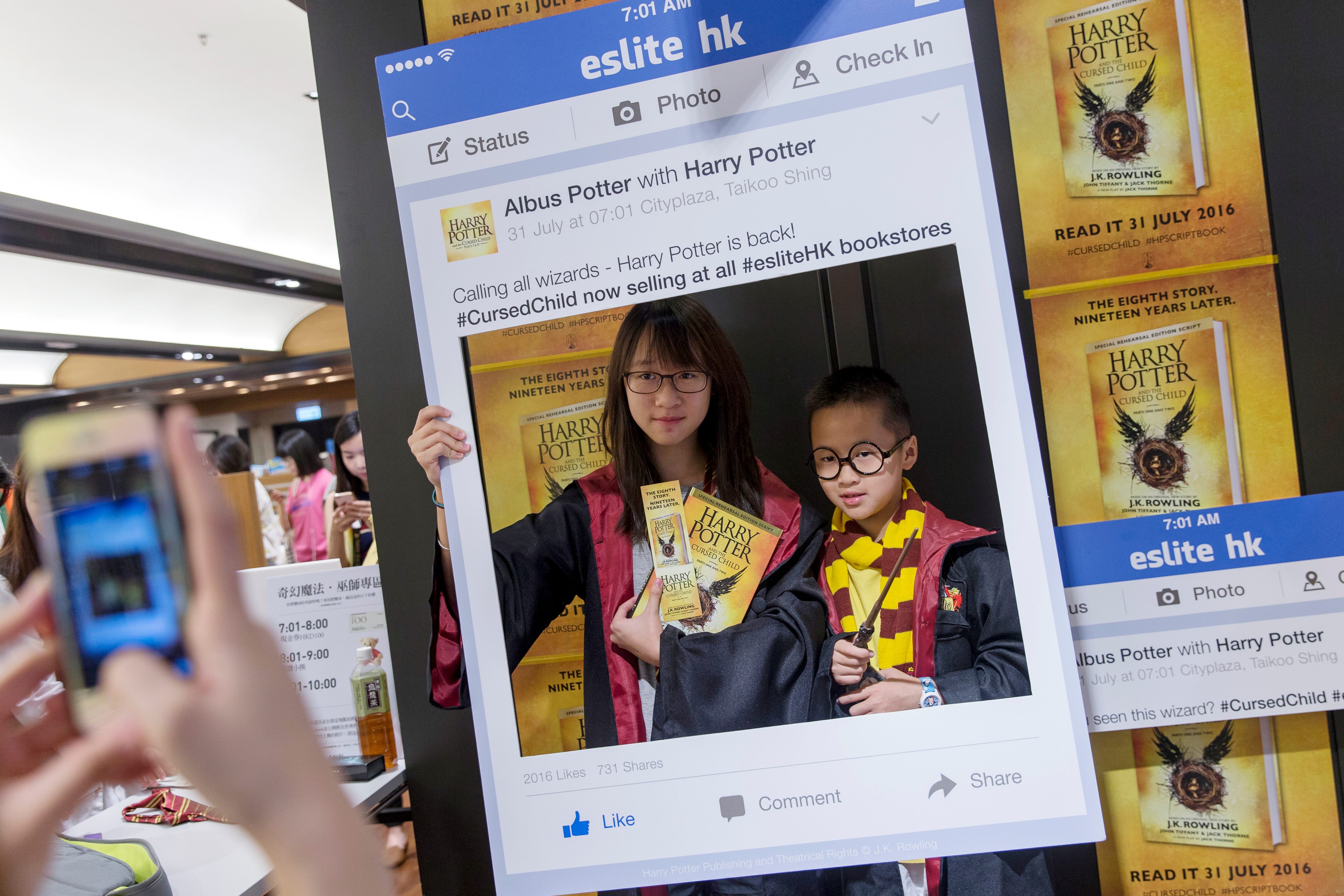 Penggemar Harry Potter berpose untuk foto dengan salinan 'Harry Potter and the Cursed Child' karya JK Rowling di toko buku di Hong Kong, Tiongkok, 31 Juli 2016. Foto Jerome Favre/EPA 