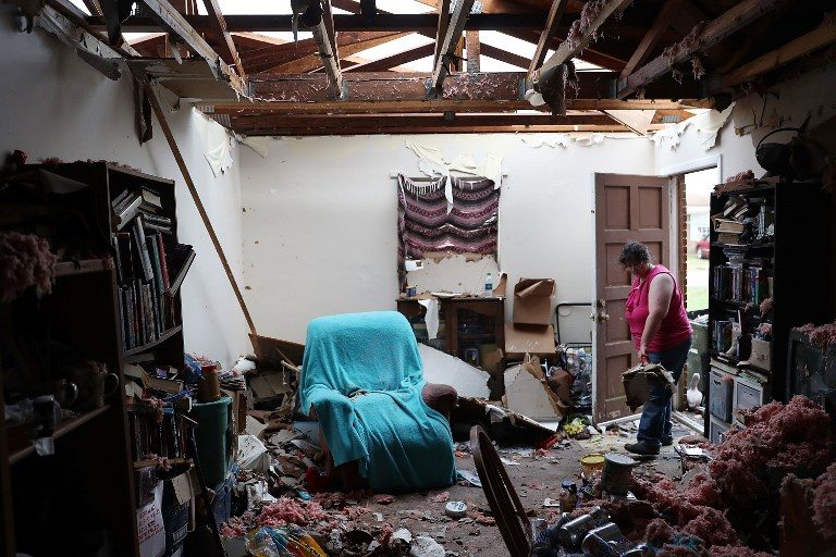 PICKING UP THE PIECES. Amanda Logsdon begins the process of trying to clean up her home after the roof was blown off by the passing winds of hurricane Michael on October 11, 2018, in Panama City, Florida.  Photo by Joe Raedle/Getty Images/AFP   