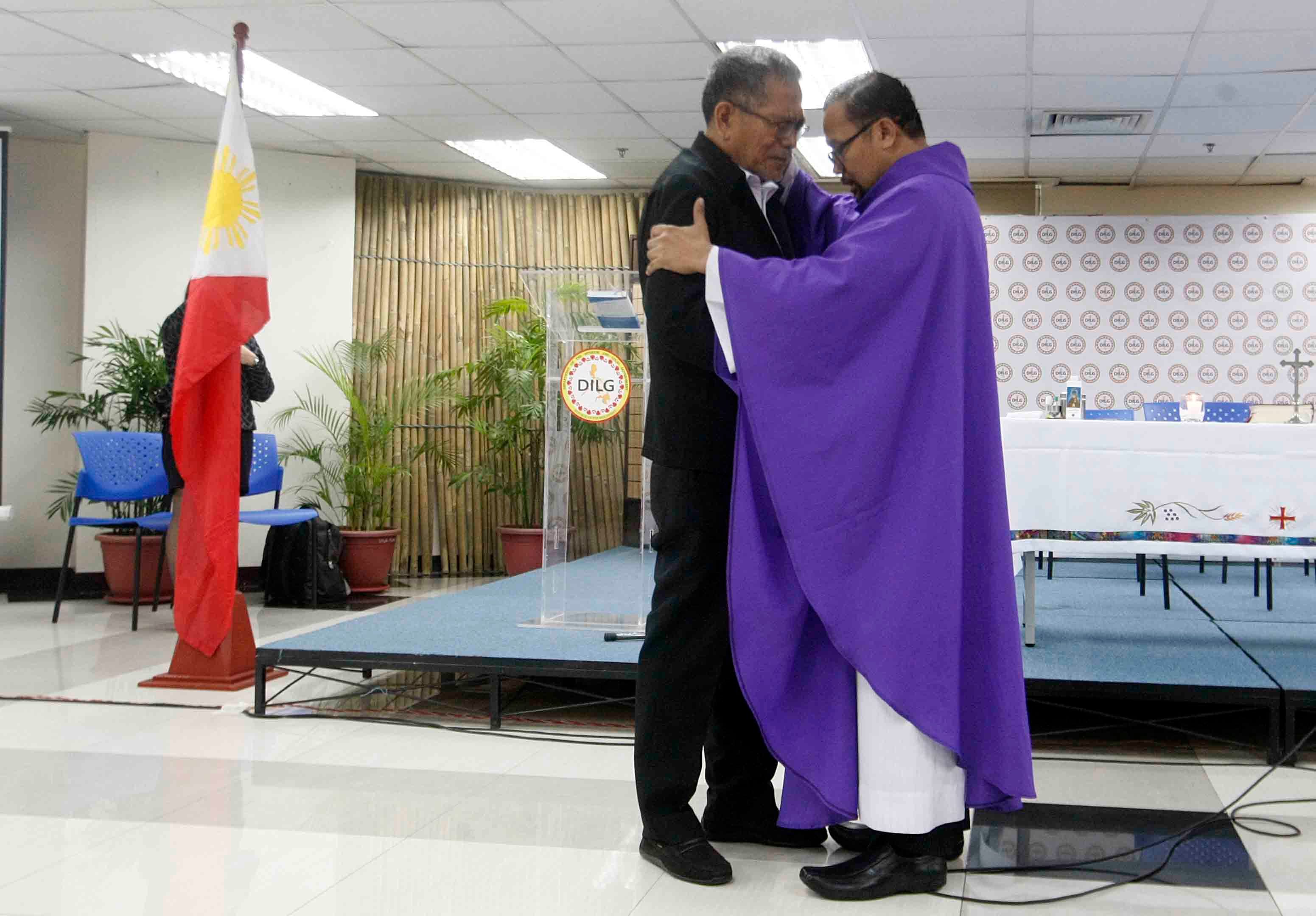 BLESSING. A priest consoles former interior secretary Ismael Sueno at his send-off at the DILG on April 6, 2017. Photo by Nelson Vera/Rappler  