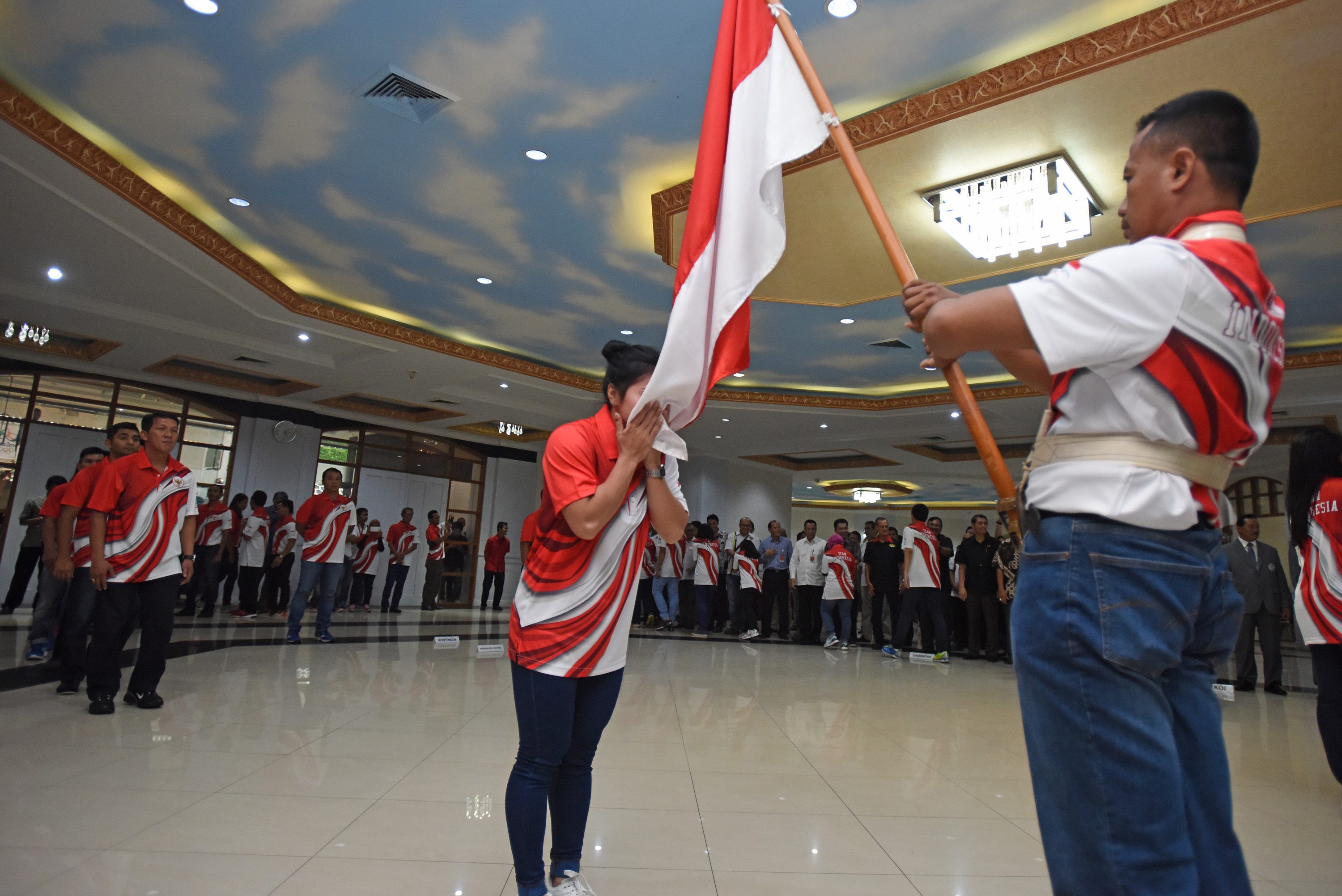 Atlet mencium bendera Merah Putih ketika mengikuti pengukuhan dan pelepasan kontingen Olimpiade di Kantor Kemenpora, Jakarta, pada 21 Juni 2016. Foto oleh Wahyu Putro A/Antara  