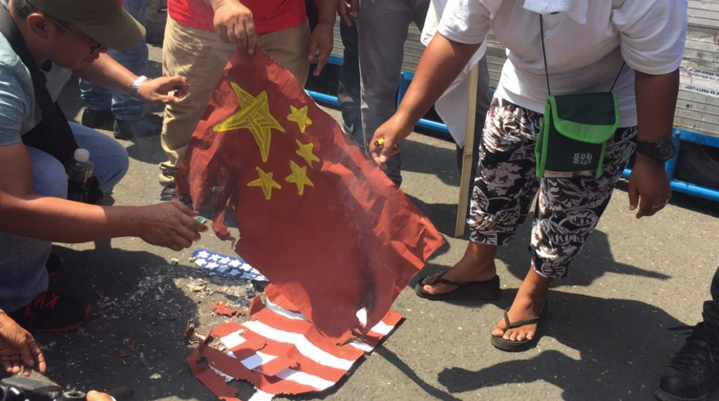 CEBU. Progressive groups burn the flags of the United States and China in front of Metro Colon in Cebu City during the Independence Day protest on Wednesday, June 12. Photo by Micole Gerard Tizon/Rappler    