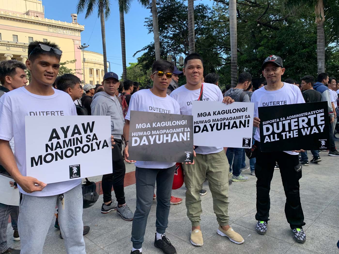 RALLY SIGNS. Members of the Duterte Quezon City Gladiators hold up signs in support of President Rodrigo Duterte and against monopolies, after Senator Koko Pimentel said he endorsed JoyRide to prevent Angkas from being a monopoly. Photo by Loreben Tuquero/Rappler 