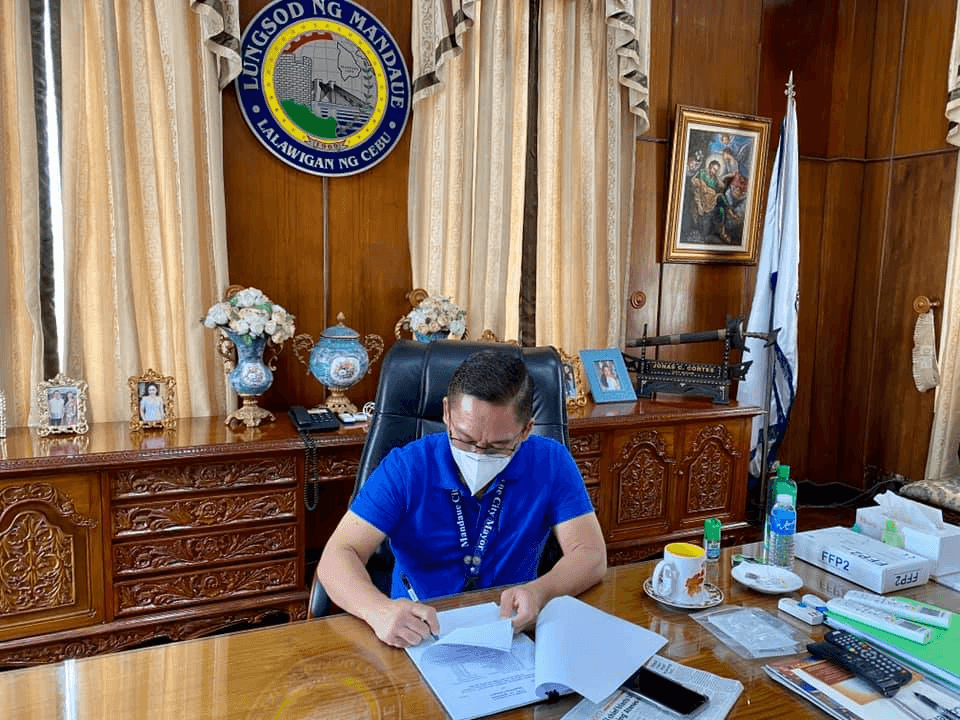MANDAUE CITY Mayor Jonas Cortes signs the ordinance that will give P200 daily hazard pay to all Mandaue City workers who physically report for work during the pandemic. Photo from Mandaue CIty PIO