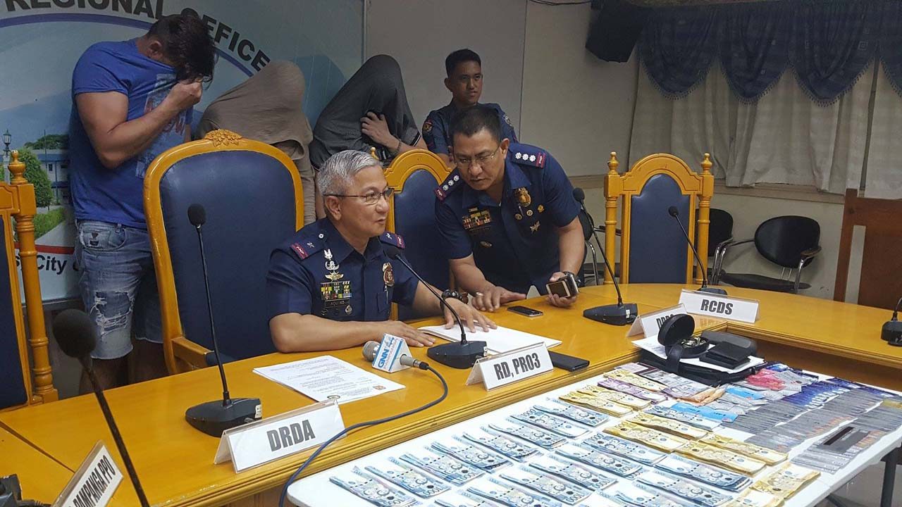 CONFISCATED. Central Luzon police director Chief Superintendent Aaron Aquino (seated) shows to media the seized cash and cloned ATM cards. Behind him are the 3 arrested foreigners. Also in photo is Pampanga police director Senior Superintendent Joel Consulta (right). Photo by Jun A. Malig/Rappler 