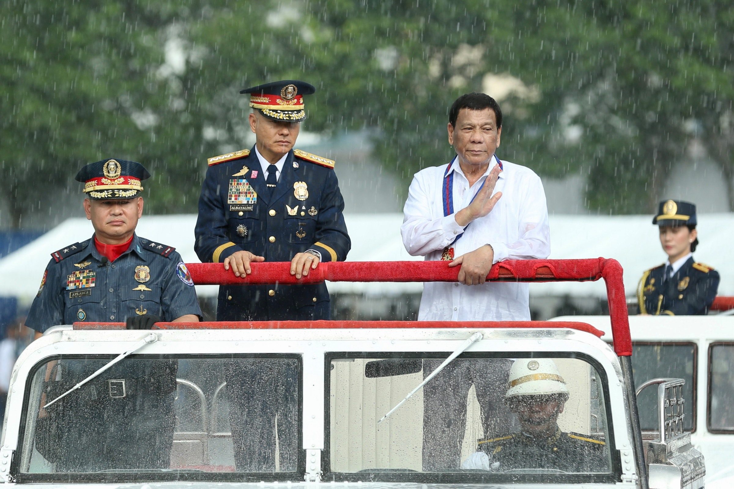 THE SHOW MUST GO ON. Inspite of the downpour, President Rodrigo Duterte leads the trooping of the line during the 117th Police Service Anniversary at  Camp Crame, Quezon City on August 8, 2018. Malacanang photo  