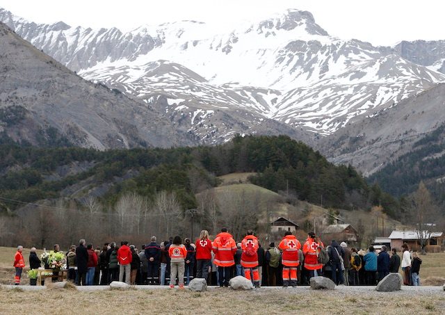 At the foot of the alps, local residents and rescue workers gather at the air crash memorial in Le Vernet, south-eastern France, 28 March 2015. Guillaume Horcajuelo/EPA 