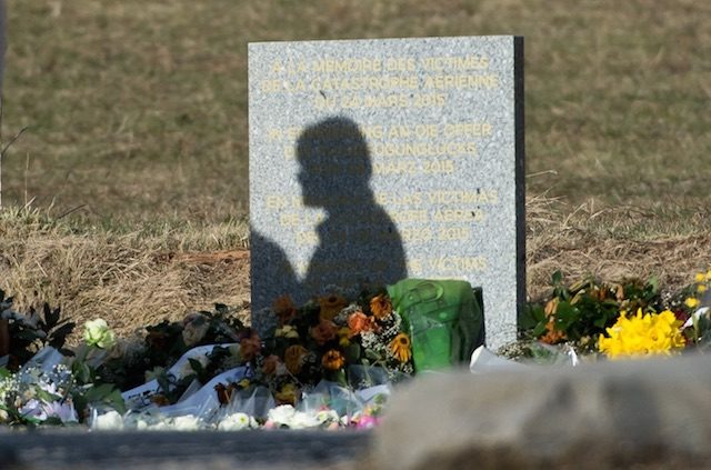 MEMORIAL. The shadow of a woman on a memorial stone for the victims of the Germanwings A320 crash in Le Vernet, France, 28 March 2015. Daniel Karmann/EPA 