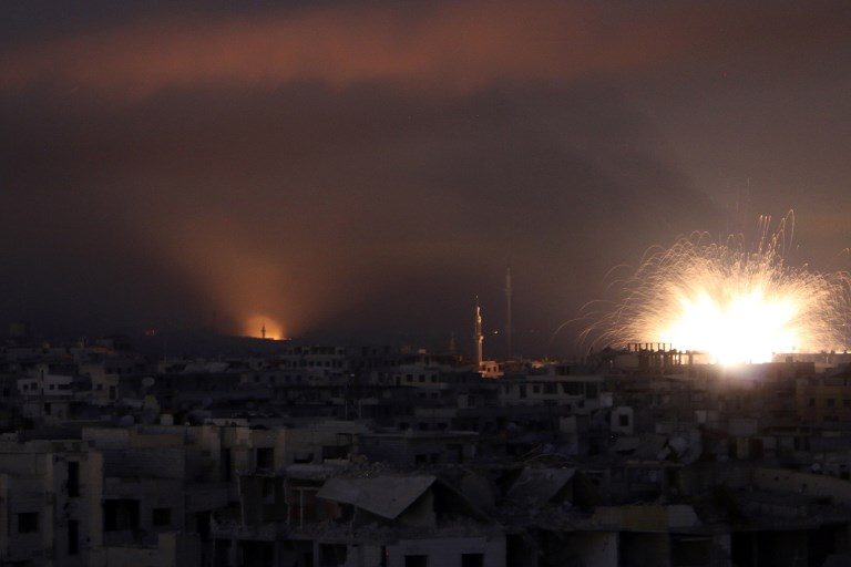 AIR STRIKE. Explosions lights the sky following Syrian government air strikes on Zamalka, in the rebel enclave of Eastern Ghouta on the outskirts of Damascus on March 12, 2018. Photo by Mohammed Eyad/AFP 
