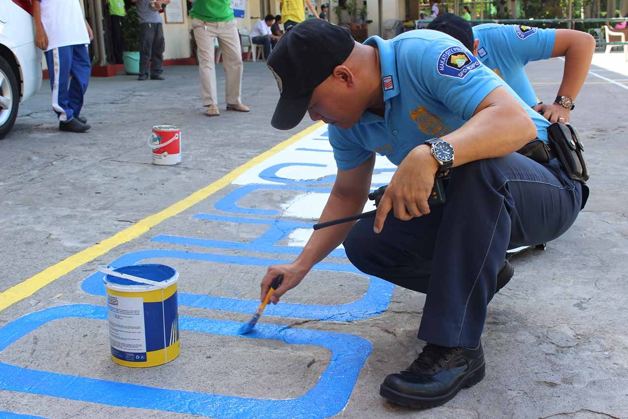 Members of the Philippine National Police repaint the basketball court  