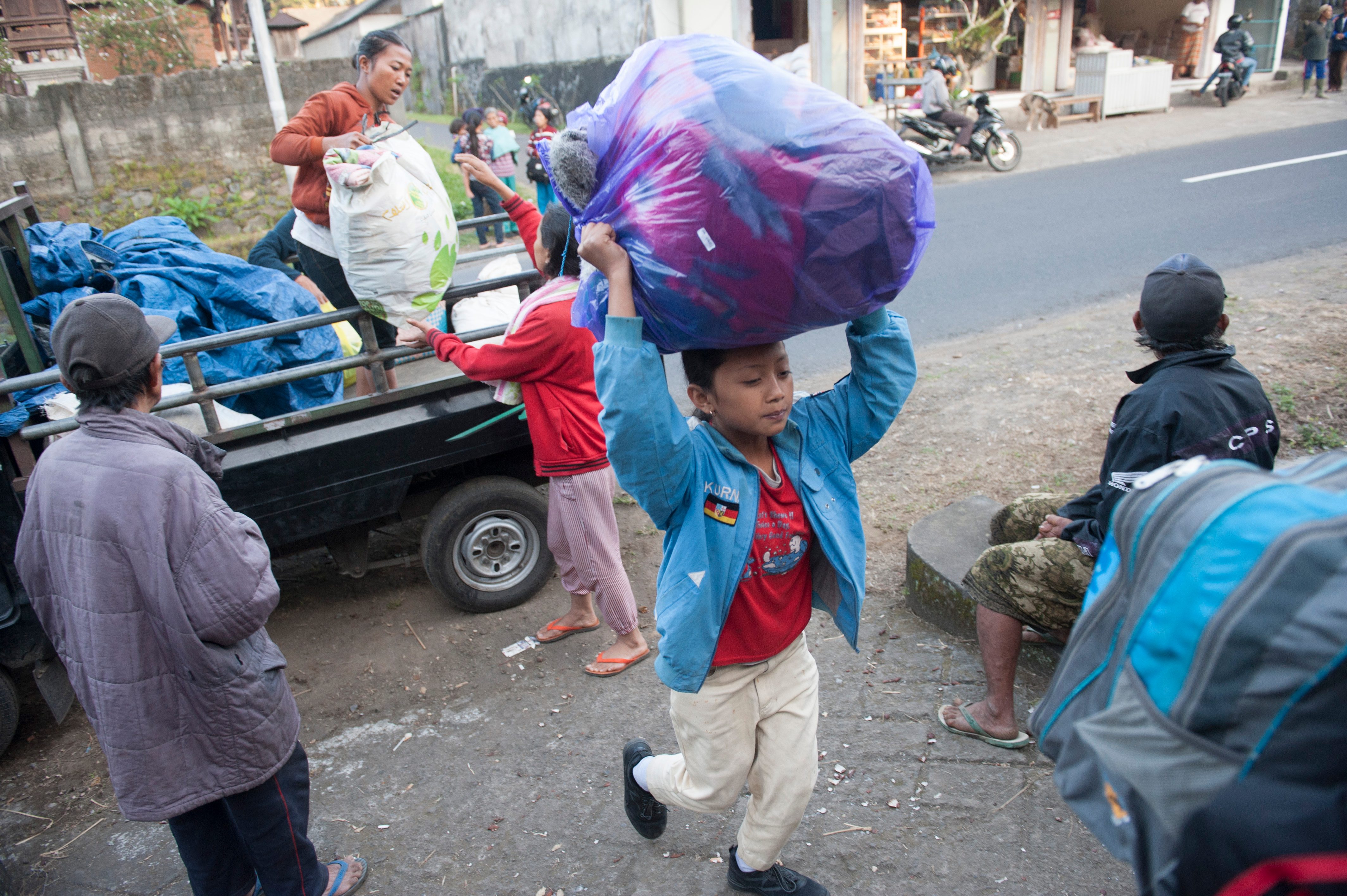 ANGKUT BARANG. Sejumlah pengungsi mengangkut barang di tempat penampungan setelah terjadinya peningkatan aktifitas Gunung Agung, di Desa Rendang, Karangasem, Bali, Kamis, 21 September. Foto oleh Nyoman Budhiana/ANTARA 