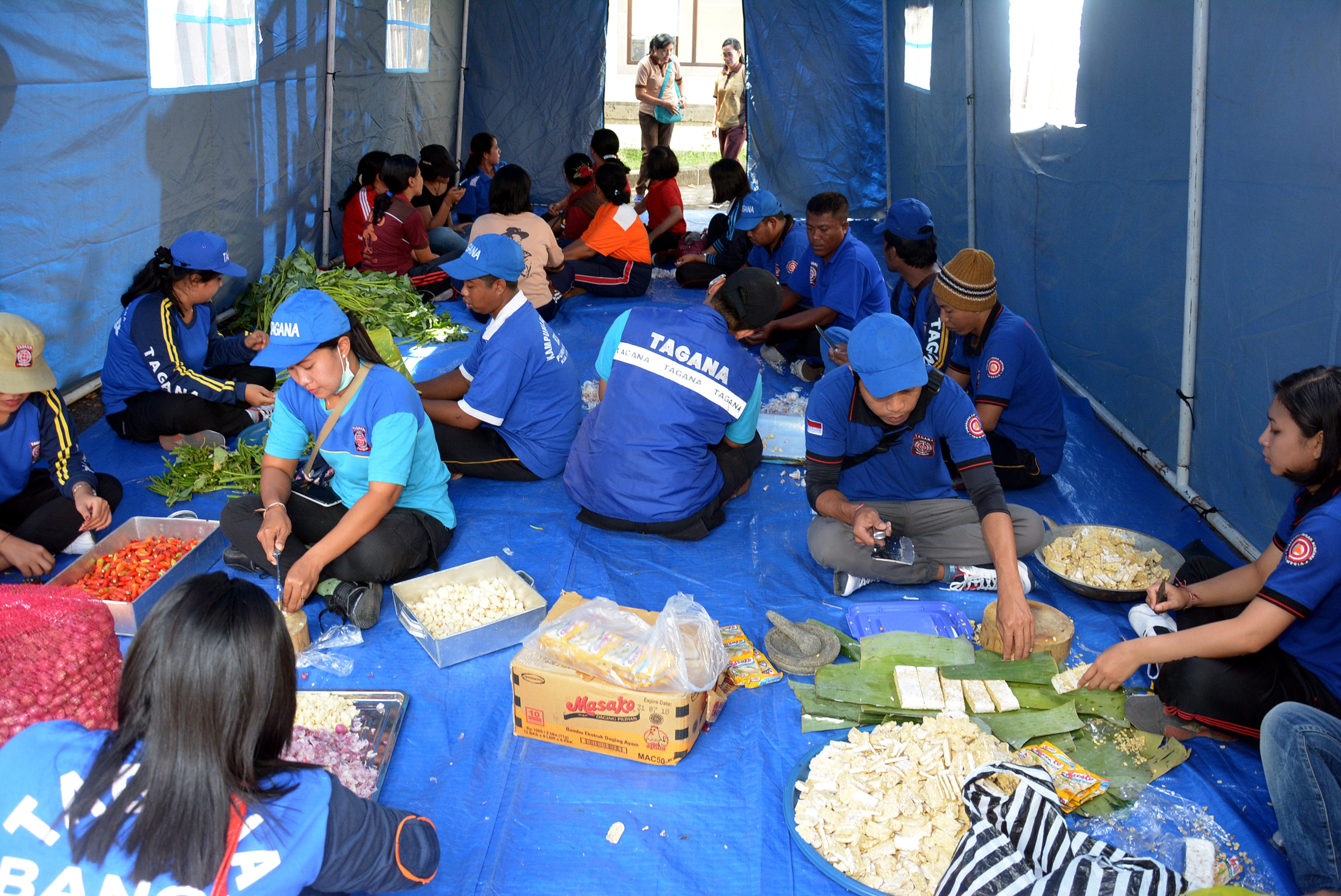 MAKANAN. Sejumlah petugas Tagana menyiapkan makanan untuk pengungsi bencana Gunung Agung di Pelabuhan Tanah Ampo, Karangasem, Bali, Kamis, 21 September. Foto oleh Wira Suryantala/ANTARA 