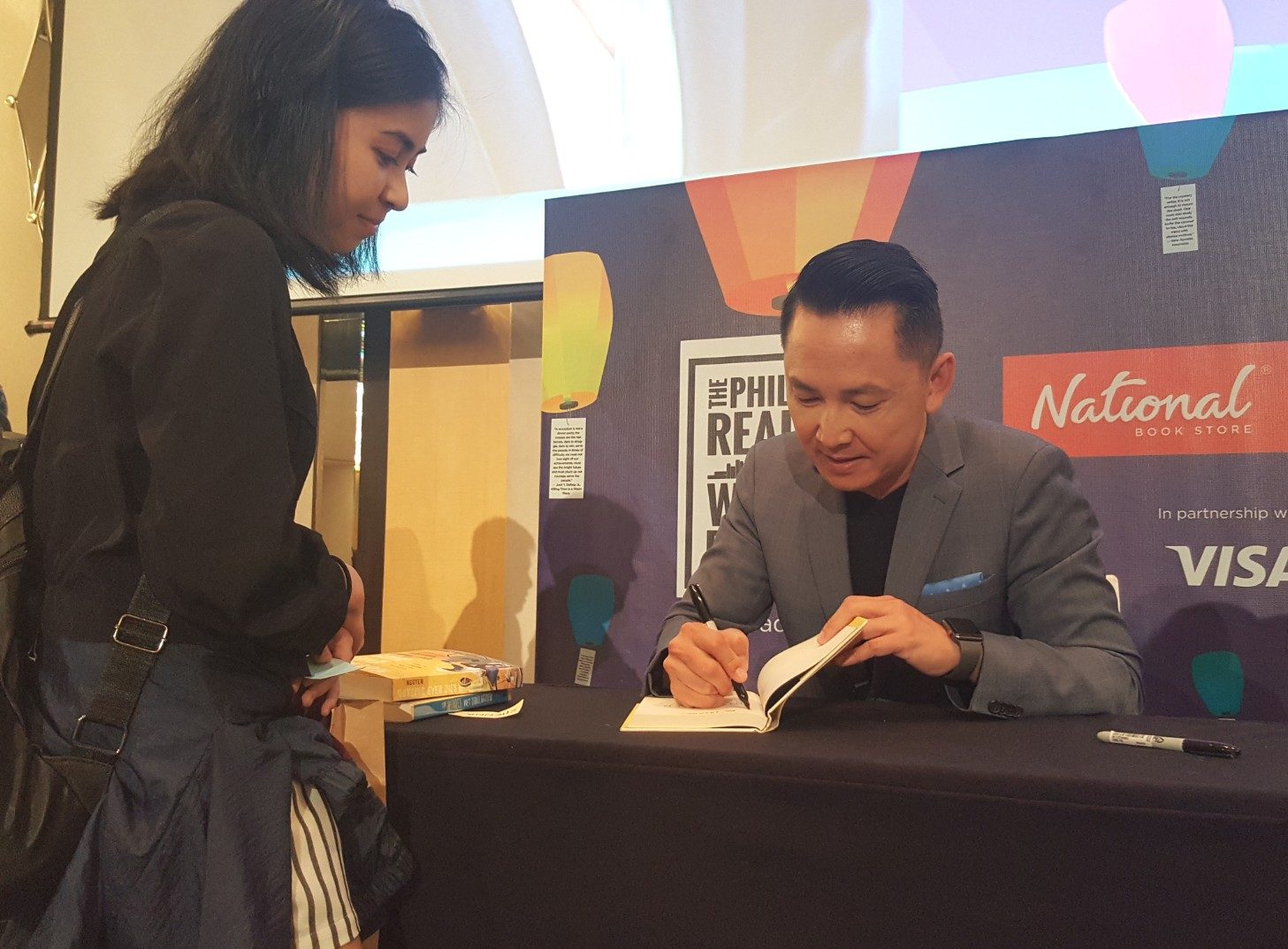 BOOK SIGNING. Viet Thanh Nguyen signs a copy of his book from one of the attendees at the festival. Photo by Alexa Villano/Rappler 