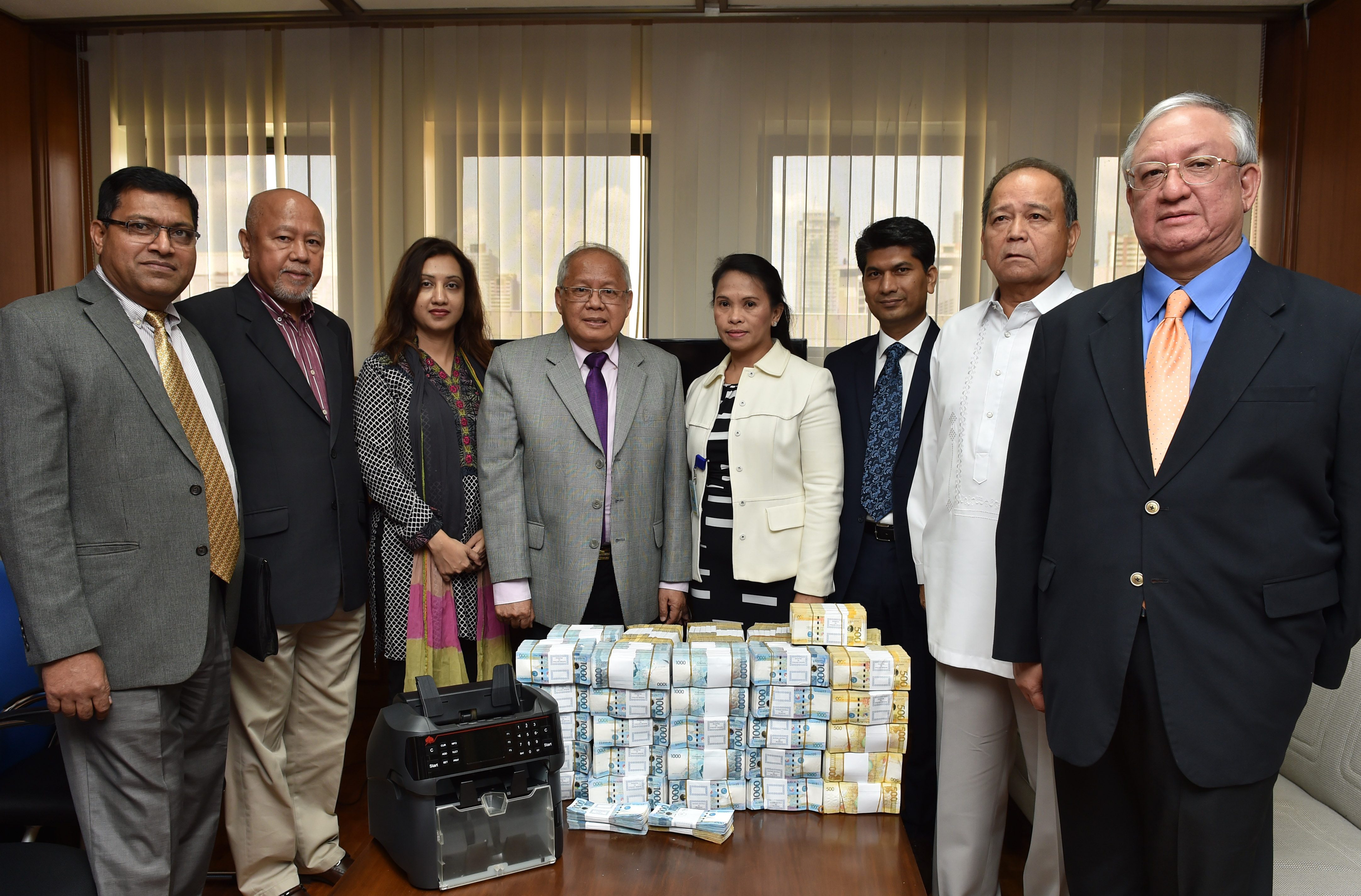 TURNOVER. (L-R)  Lawyers Victor Fernandez (second from right), and Inocencio Ferrer Jr (rightmost) turn over P38.28 million of stolen funds to AMLC. Photo from BSP  