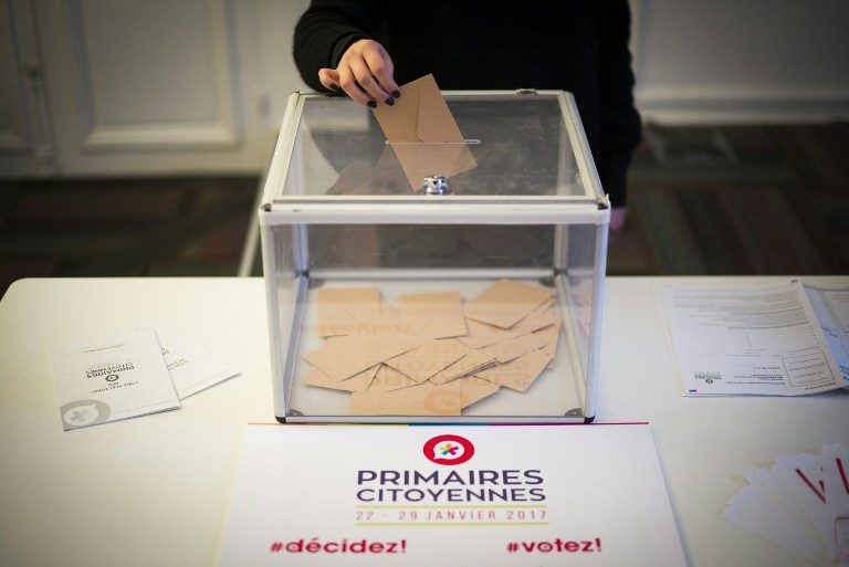 PRIMARY VOTE. A woman casts a ballot next to a placard for the left-wing primaries ahead of France's 2017 presidential election on January 16, 2017 in Paris. Martin Bureau/AFP 