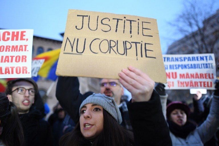 A woman holds a placard reading 'Justice not Corruption' during a protest against the corruption and the government in Bucharest January 22, 2017. Daniel Mihailescu/AFP 