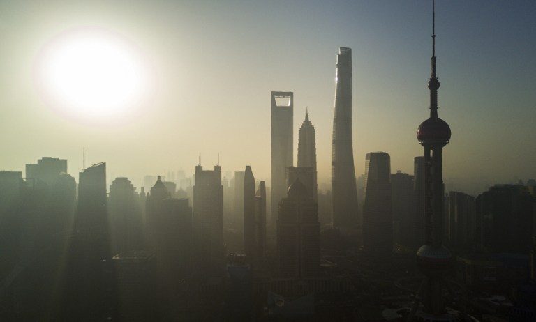 The sun rises behind the skyline of Shanghai in the Lujiazui Financial District of Pudong on November 11, 2016. Johannes Eisele/AFP 