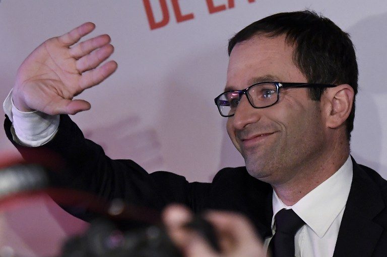 French former minister and candidate for the left-wing primaries, Benoit Hamon, greets supporters as he arrives on stage to deliver a speech at his campaign headquarters after the first round of the left-wing primary for the 2017 French presidential election, on January 22, 2017 in central Paris. Bertrand Guay/AFP 