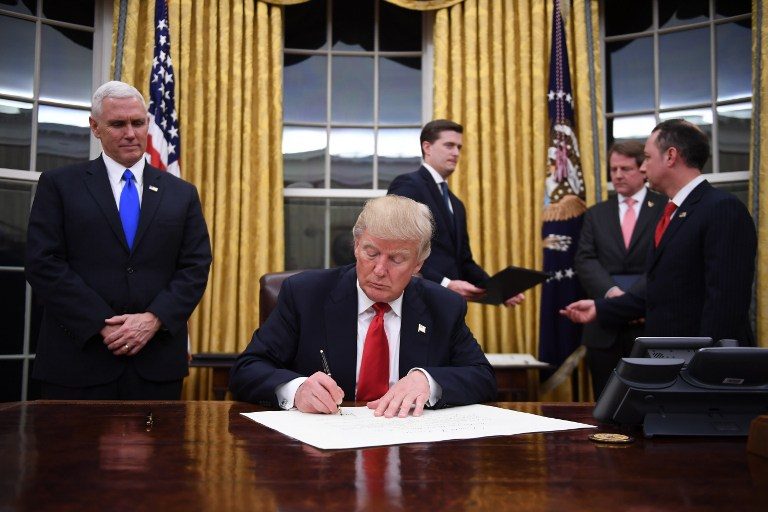 US President Donald Trump signs a confirmation for John Kelly as US Secretary of Homeland Security, as Vice President Mike Pence (L) and White House Chief of Staff Reince Priebus (R) look on, in the Oval Office of the White House in Washington, DC, January 20, 2017. Jim Watson/AFP 