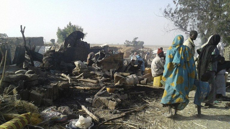 This handout image received courtesy of Doctors Without Border (MSF) on January 17, 2017, shows people standing next to destruction after an air force jet accidentally bombarded a camp for those displaced by Boko Haram Islamists, in Rann, northeast Nigeria. Medecins Sans Frontieres/Handout/AFP 