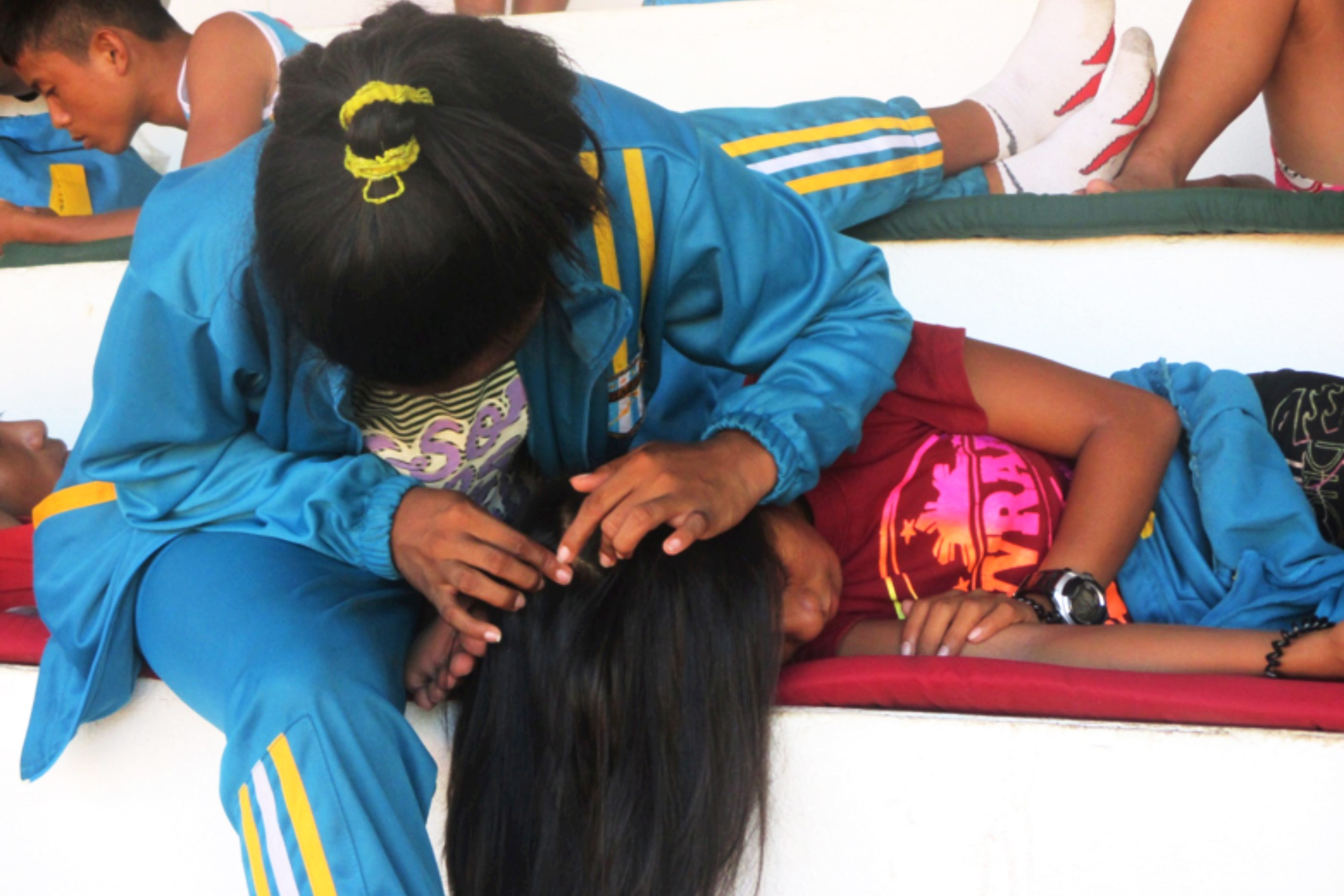 A GIRL THING. A coach checks the head of one of her athlete for hygiene during a break. Photo by Trisha Mae Arias/Rappler  