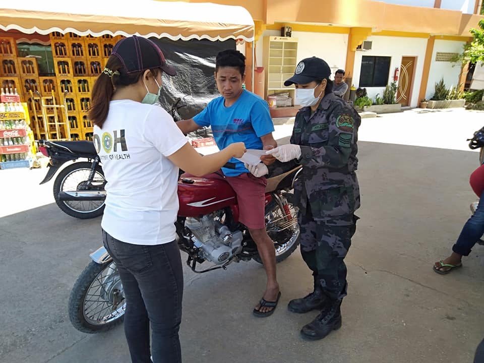 SAFETY MEASURE. An employee of the Department of Health and a policewoman checks the document of a motorcycle rider. Photo courtesy of PRO11 