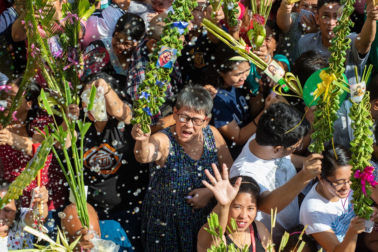 HOLY WATER. Priests sprinkle holy water on thousands of Catholics who join the Palm Sunday observance at Santo Niño Parish in Tondo, Manila, on April 14, 2019. Photo by Maria Tan/Rappler  