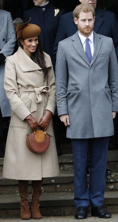 FIANCEE DUTIES. US actress and fiancee of Britain's Prince Harry Meghan Markle (L) and Britain's Prince Harry (R) stand together as they wait to see off Britain's Queen Elizabeth II after attending the Royal Family's traditional Christmas Day church service at St Mary Magdalene Church in Sandringham, Norfolk, eastern England, on December 25, 2017.  Photo by Adrian Dennis/AFP 