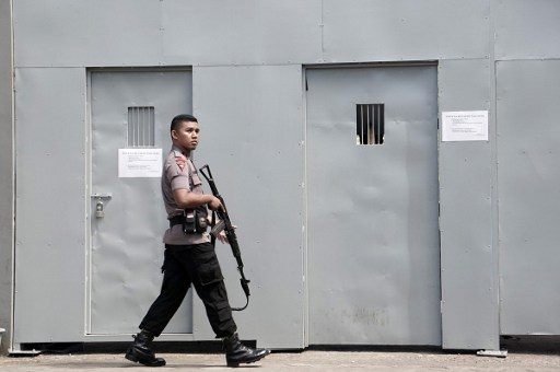 HIGH SECURITY. An Indonesian policeman guards outside a metal gate at the Cilacap port, the only gate to Indonesia's highest security Nusakambangan prison in Cilacap. AFP   