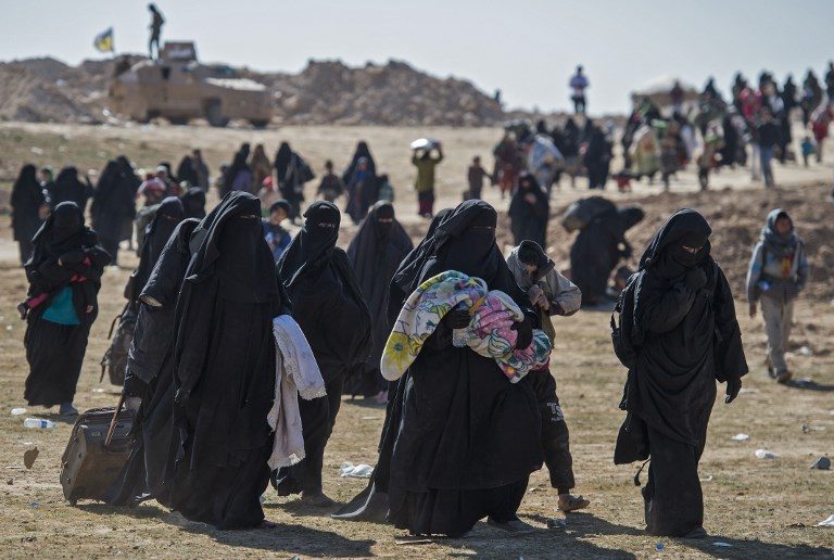 ESCAPE. Fully veiled women and children flee the Baghouz area in the eastern Syrian province of Deir Ezzor on February 12, 2019, during an operation by the US-backed Syrian Democratic Forces to expel hundreds of Islamic State group jihadists from the region. Photo by Fadel Senna/AFP  