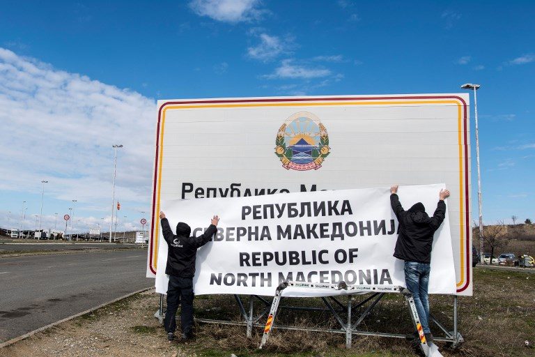 NEW COUNTRY NAME. People work to change the sign at the border between Macedonia and Greece near Gevgelija on February 13, 2019, after a deal between Skopje and Athens to rename Macedonia as North Macedonia came into force on February 12, 2019. Photo by Robert Atanasovski/AFP  