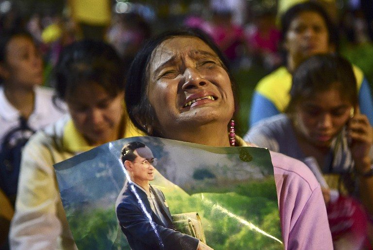 IN MOURNING. A woman holds a photo of Thailand's King Bhumibol Adulyadej as people react to his death on October 13, 2016 at Siriraj Hospital in Bangkok. Photo by Munir Uz Zaman/AFP    
