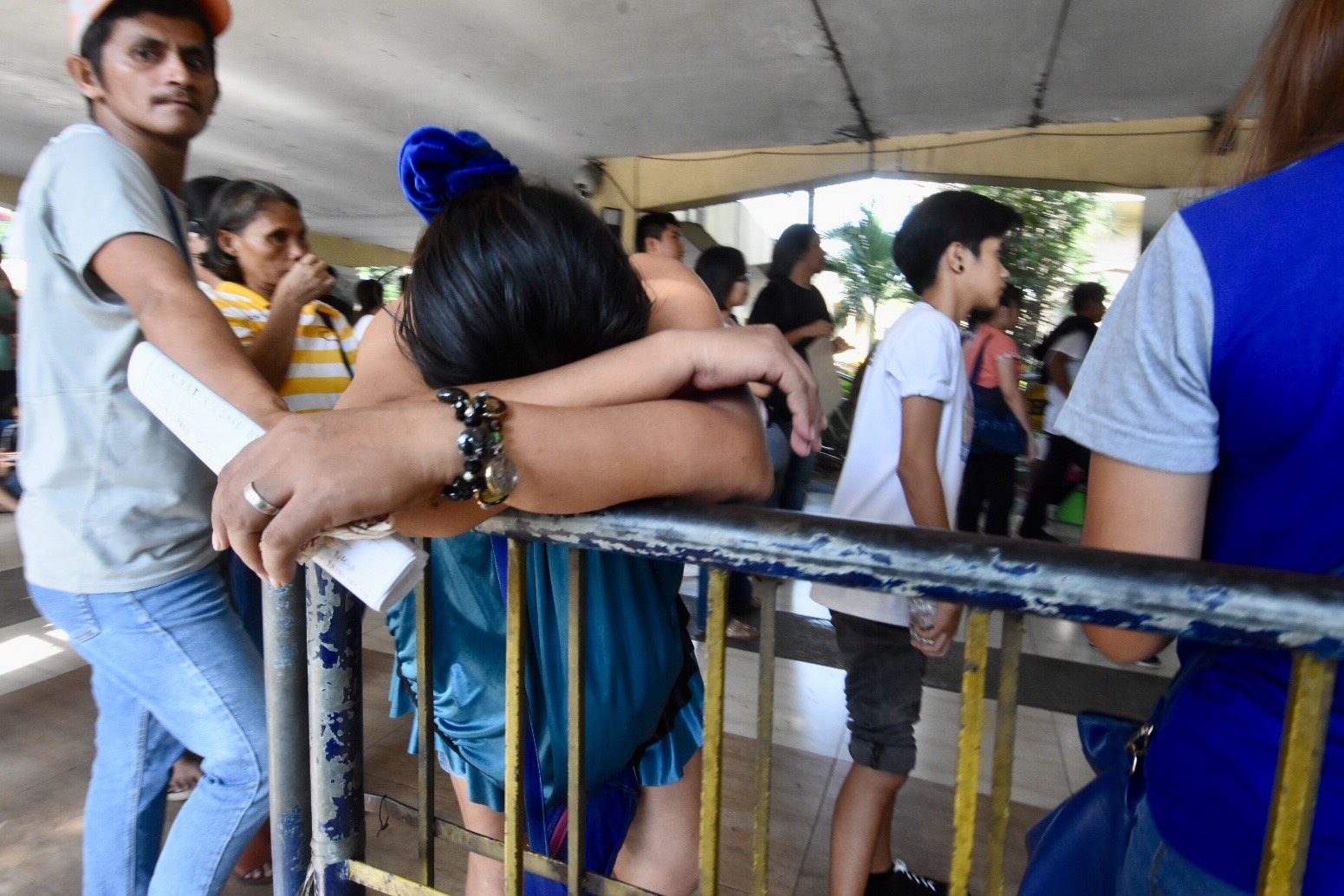 EXHAUSTED. A woman slumps on the railing as she waits for her turn to register. Photo by Angie de Silva/Rappler 