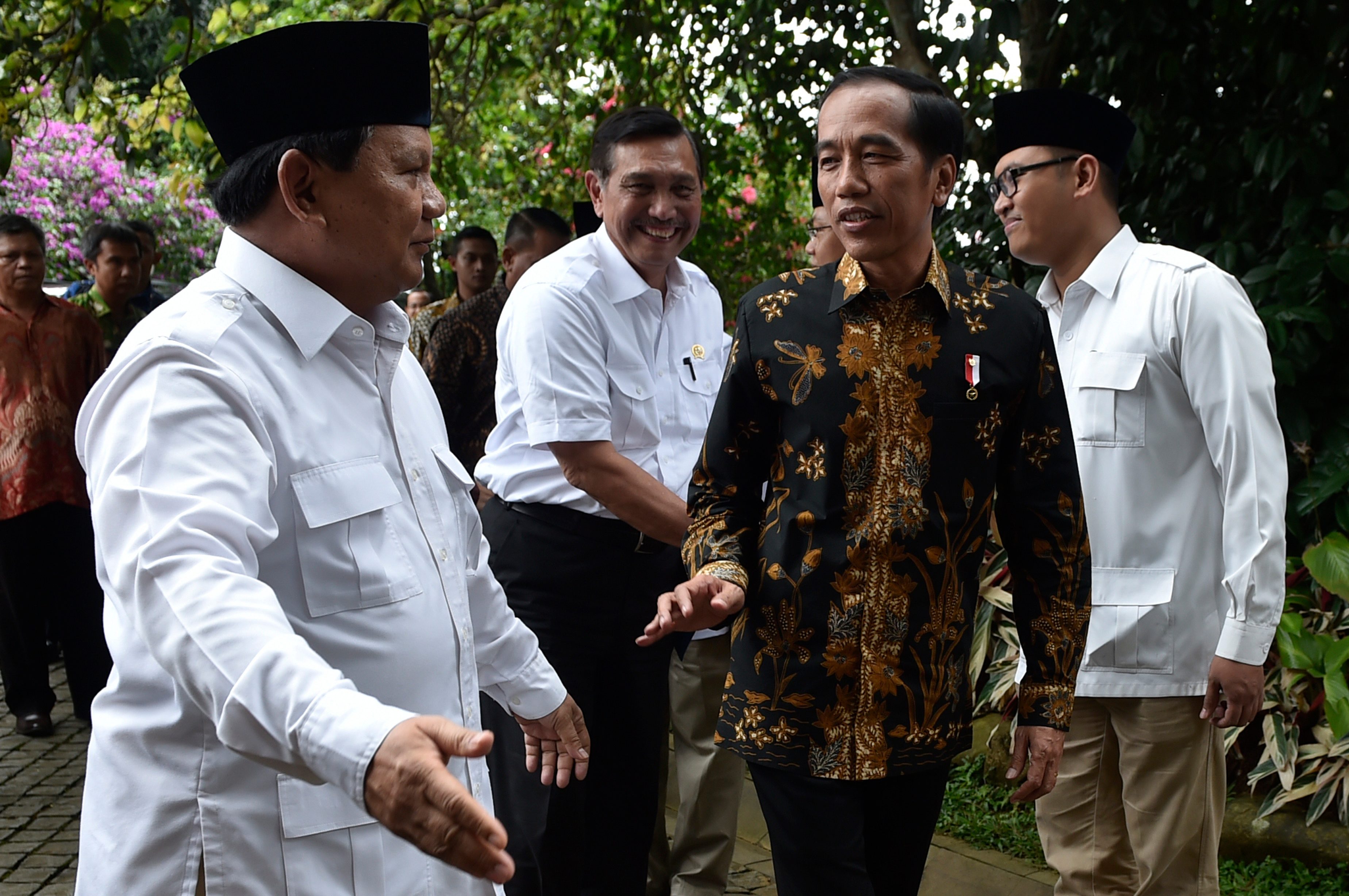 Jokowi (tengah) dan Prabowo (kiri) menyampaikan keterangan pers usai bertemu di kediaman Prabowo di Hambalang, Bogor, Jawa Barat, pada 31 Oktober 2016. Foto oleh Puspa Perwitasari/Antara    