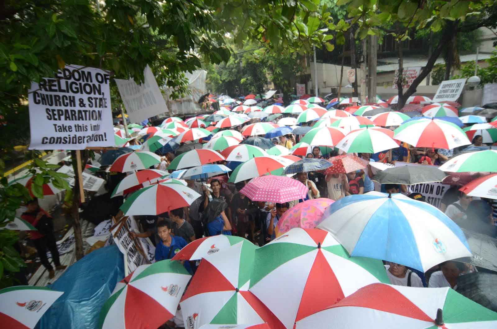 PROTEST. Despite the heavy downpour, INC members continue their program in front of the DOJ on the second day of their vigil. File photo by Alecs Ongcal/Rappler 