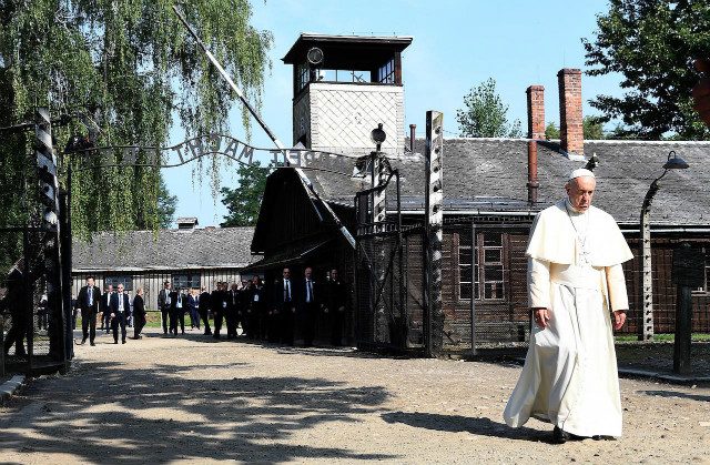 Pope Francis walks alone through Auschwitz