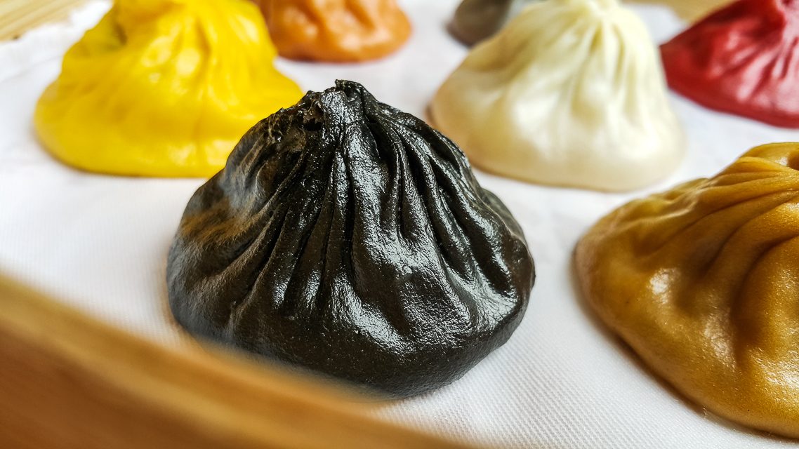 There lies the black truffle xiao long bao, occupying the basket as a jewel might adorn a crown. Photo by Wyatt Ong/Rappler   