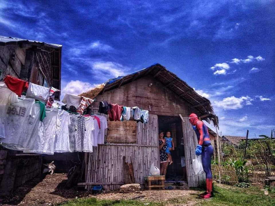 LOCAL HEROES. Bicolano Spiderman, with AReiz Macaraig, delivers food packs to Zone 7, Barangay Abella, Naga City. Photo courtesy of Ongen Cañizo Pante-Bočkay  