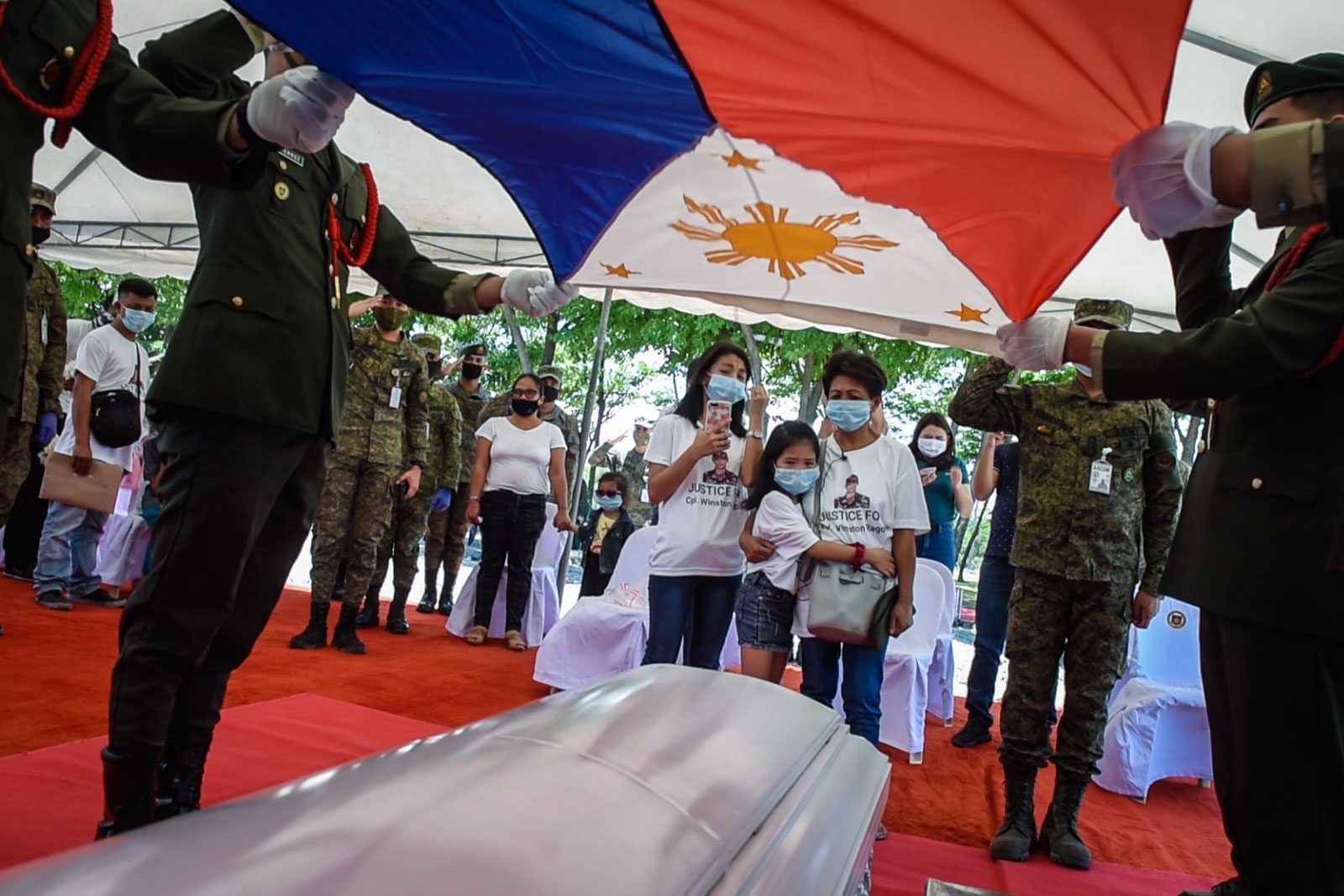 HONOR. The Armed Forces of the Philippines honors one of its own through the Philippine flag as it lays to rest Corporal Winston Ragos, the retired military man who died in the hands of the police. Photo by Alecs Ongcal/Rappler 