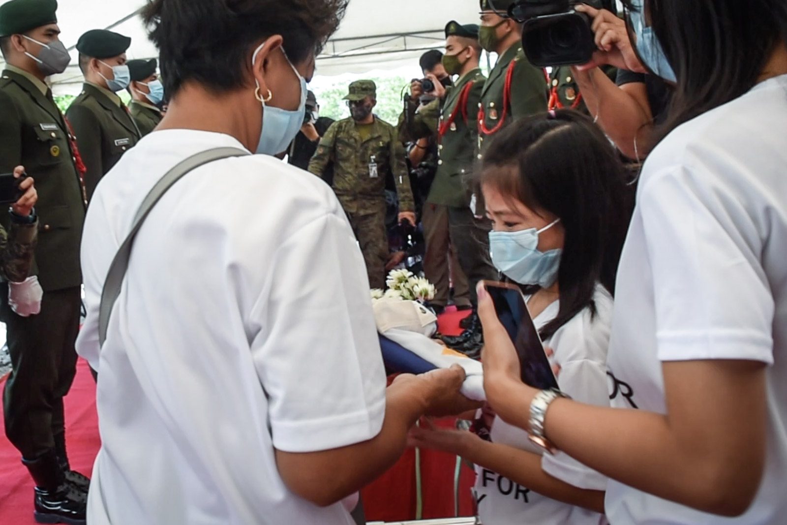 The family of Corporal Winston Ragos receives the Philippine flag from the military after he was laid to rest at the Libingan ng mga Bayani on Sunday, April 26, 2020. Photo by Alecs Ongcal/Rappler 