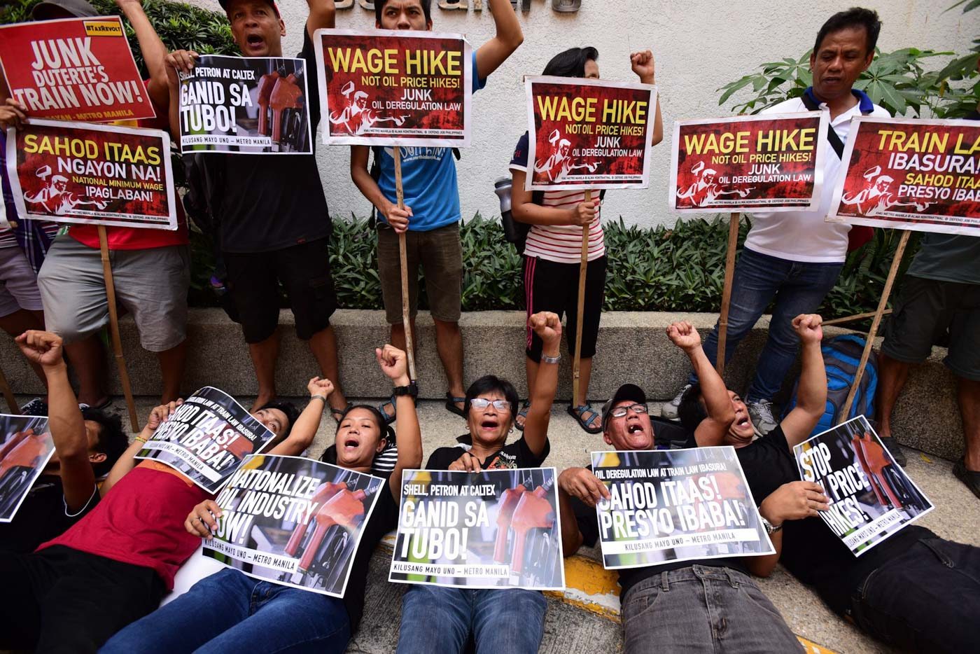 TRIPLE WHAMMY PROTEST. Militant labor group Kilusang Mayo Uno stage a die-in protest in government and private offices in Makati City on May 29, 2018 to call attention to various issues such as the rising prices of basic commodities, low wages, and labor contractualization. Photo by Maria Tan/Rappler  