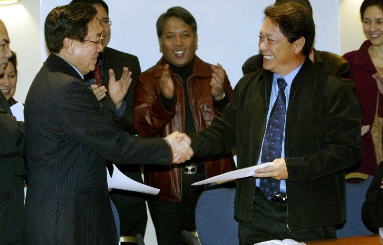 RESUMPTION. Goverment chief negotiator Silvestre Bello III (R) and the head of the Communist rebel delegation Luis Jalandoni shake hands February 14, 2004 after signing a joint statement, putting the peace process back on track, more than two years after the first talks collapsed. AFP photo   