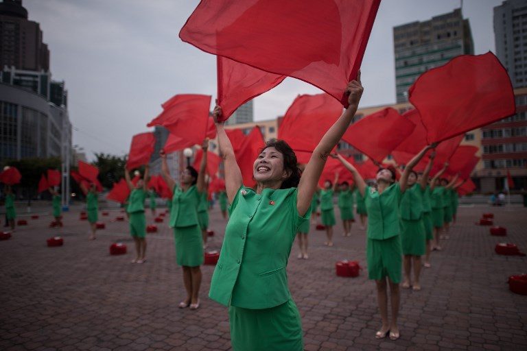 PARADE PRACTICE. A propaganda troupe performs a flag-waving routine outside the central railway station in Pyongyang on September 27, 2017. Photo by Ed Jones/AFP  