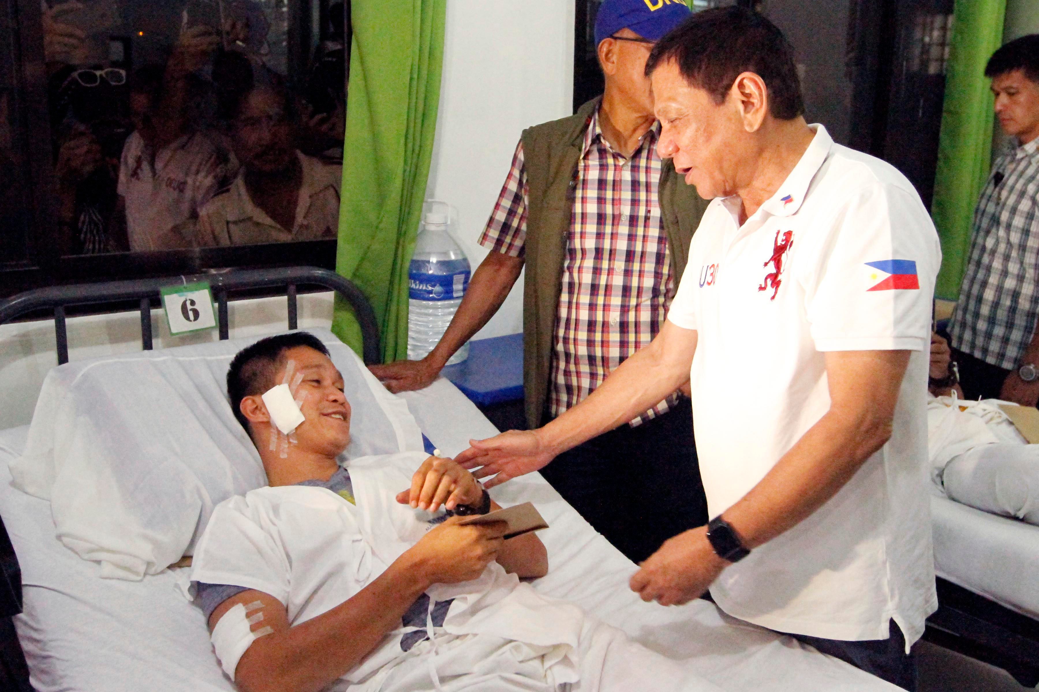 TRIBUTE TO THE WOUNDED. President Rodrigo Duterte visits a wounded soldier at Camp Navarro General Hospital in Zamboanga City on July 22, 2016. Photo by Benjamin Basug/NIB  