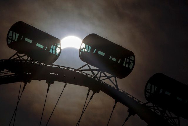 THE FLYER AND THE SUN. A partial solar eclipse is seen above cabins of the Singapore Flyer at dawn in Singapore, March 9, 2016. Wallace Woon/EPA 